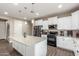 Well-lit kitchen with white cabinets, granite counters, a large island, and modern stainless steel appliances at 13603 W Remuda Dr, Peoria, AZ 85383
