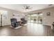 Cozy living room with wood-look tile flooring, ceiling fan, and sliding glass doors to the backyard at 13603 W Remuda Dr, Peoria, AZ 85383