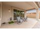 Covered patio with outdoor seating, tile flooring, neutral paint, and sliding glass doors leading to the interior at 13603 W Remuda Dr, Peoria, AZ 85383