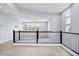 This bonus room includes high ceilings, lots of windows, and black metal railing at 1372 N Zane Dr, Chandler, AZ 85226