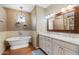 Bathroom features a soaking tub, chandelier, and a vanity with double sinks at 15221 N Clubgate Dr # 2061, Scottsdale, AZ 85254