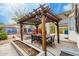 Backyard space includes an outdoor kitchen area and a long wooden dining table under a shaded pergola at 1622 E Silverbirch Ave, Buckeye, AZ 85326