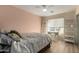 Cozy bedroom features a ceiling fan, white shelving and an inviting desk area with a window at 1622 E Silverbirch Ave, Buckeye, AZ 85326