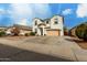 Charming stucco two-story home with a two-car garage, desert landscaping, and covered entry at 1622 E Silverbirch Ave, Buckeye, AZ 85326