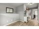 Hallway featuring a gray color palette, wood floors, a decorative shelf, and doorway to a bathroom at 1622 E Silverbirch Ave, Buckeye, AZ 85326