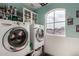 Light and bright laundry room with shelving, cabinet storage, and a modern washer and dryer at 1622 E Silverbirch Ave, Buckeye, AZ 85326
