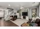 Bright, open-concept living room with hardwood floors, stairway, entertainment center, and leather seating at 1622 E Silverbirch Ave, Buckeye, AZ 85326