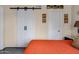 Bedroom with wood floors, an orange comforter and white barn door leading to ensuite at 16624 E Palisades Blvd # 101, Fountain Hills, AZ 85268