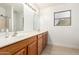 Bright bathroom featuring double sinks, light wood cabinetry, and tiled floors at 1805 E Sagebrush St, Gilbert, AZ 85296
