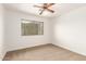 Empty bedroom featuring neutral carpet, a ceiling fan, and a window for natural light at 1805 E Sagebrush St, Gilbert, AZ 85296