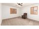 This bedroom features neutral carpet, ceiling fan, and windows with wood-trimmed shutters at 1805 E Sagebrush St, Gilbert, AZ 85296