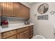 Well-organized laundry room featuring wooden cabinets, white counters, and neutral walls at 18610 E Amarado Cir, Rio Verde, AZ 85263