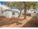 Home's backyard featuring white siding, mature trees, storage shed, and block fence at 1900 S Coconino Dr, Apache Junction, AZ 85120