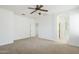 Main bedroom featuring carpeted floors, a ceiling fan and bathroom entrance at 19013 E Seagull Dr, Queen Creek, AZ 85142
