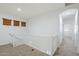Second floor landing with carpeted floor, white banister and natural light at 19013 E Seagull Dr, Queen Creek, AZ 85142