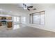 Cozy living room leading into kitchen with an open layout, ceiling fan, and lots of natural light at 19013 E Seagull Dr, Queen Creek, AZ 85142