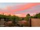 Pink sunset over the backyard fence and landscaping, highlighting a serene outdoor space at 20630 N 42Nd Ave, Glendale, AZ 85308