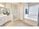 Bright bathroom with a glass-enclosed shower, bathtub, and vanity at 20630 N 42Nd Ave, Glendale, AZ 85308