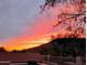 Back patio view with a fiery sunset backdrop, highlighting the outdoor living space at 20630 N 42Nd Ave, Glendale, AZ 85308