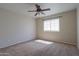 Comfortable bedroom featuring neutral carpet, fan, and a window with blinds at 2077 N Lake Shore Dr, Casa Grande, AZ 85122
