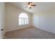 Spacious bedroom with neutral carpet, fan, and window with plantation shutters at 2077 N Lake Shore Dr, Casa Grande, AZ 85122