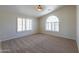 Spacious bedroom featuring neutral walls, carpeted floors, large windows, and a ceiling fan at 2077 N Lake Shore Dr, Casa Grande, AZ 85122