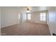 Spacious living room featuring plush carpet, natural light and access to bathroom at 2077 N Lake Shore Dr, Casa Grande, AZ 85122