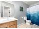 Well-lit bathroom featuring a modern vanity, toilet, and shower with decorative blue shower curtain at 23359 W Cocopah St, Buckeye, AZ 85326