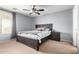 Bedroom with a ceiling fan, dark wood bed frame and side table, with a window letting in natural light at 23359 W Cocopah St, Buckeye, AZ 85326