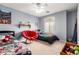 Shared bedroom with twin beds, a ceiling fan, and a cozy red papasan chair at 23359 W Cocopah St, Buckeye, AZ 85326