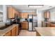 Well-lit kitchen with stainless steel appliances and wooden cabinetry at 23359 W Cocopah St, Buckeye, AZ 85326