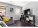 Cozy living room featuring hardwood floors, a gray sofa, and a tv stand at 23359 W Cocopah St, Buckeye, AZ 85326