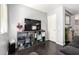 Modern living room featuring dark wood floors and a gray shelving unit with TV at 23359 W Cocopah St, Buckeye, AZ 85326