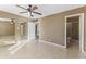 Spacious bedroom with neutral-toned walls, tile floors, ceiling fan, and access to two additional rooms at 2348 W Laurel Ln, Phoenix, AZ 85029