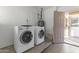Laundry room with white washer and dryer, beige door and white walls at 2348 W Laurel Ln, Phoenix, AZ 85029