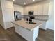 Bright kitchen featuring white cabinets, stainless steel appliances, a large island, and hardwood floors at 25156 W Wayland Dr, Buckeye, AZ 85326