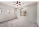 This spacious bedroom has neutral paint, a ceiling fan, carpet and natural light from three windows at 2600 E Springfield Pl # 10, Chandler, AZ 85286