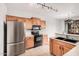 Well-equipped kitchen with stainless steel refrigerator, oak cabinets, and modern appliances at 2600 E Springfield Pl # 10, Chandler, AZ 85286