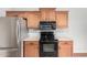 Functional kitchen with stainless steel refrigerator, oak cabinets and black appliances at 2600 E Springfield Pl # 10, Chandler, AZ 85286