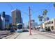 Modern Phoenix light rail train running on a city street with contemporary buildings and tall palm trees at 3131 N Central Ave # 3001, Phoenix, AZ 85012