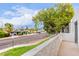 Balcony view featuring a lush green tree, the neighborhood street, and residential buildings under a bright sky at 3314 N 68Th St # 247, Scottsdale, AZ 85251