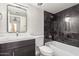 Stylish bathroom features a dark vanity, tub and shower combo with black tile, plus an elegant mirror at 3314 N 68Th St # 247, Scottsdale, AZ 85251