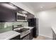 Modern kitchen featuring stainless steel appliances, dark cabinets, and a stylish backsplash for a sleek design at 3314 N 68Th St # 247, Scottsdale, AZ 85251