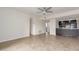 Bright living room with ceiling fan and adjacent kitchen featuring dark cabinetry and tile flooring at 3314 N 68Th St # 247, Scottsdale, AZ 85251