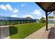 Lush backyard featuring a pergola, well-maintained artificial grass, and a mural backdrop at 33290 N Roadrunner Ln, San Tan Valley, AZ 85144