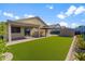 Wide shot of a spacious backyard with artificial grass, covered patio, and exterior storage at 33290 N Roadrunner Ln, San Tan Valley, AZ 85144