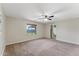 Large bedroom with neutral carpet, a window overlooking a garden, and an ensuite bathroom entrance at 33290 N Roadrunner Ln, San Tan Valley, AZ 85144