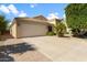 Exterior view of home showcasing a two-car garage, desert landscaping, and concrete driveway at 33290 N Roadrunner Ln, San Tan Valley, AZ 85144