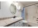 Cozy bathroom with tiled countertop, oval mirror, toilet, and shower featuring blue and white patterned curtain at 3345 E University Dr # 29, Mesa, AZ 85213