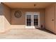 Covered patio with brick flooring, white double doors, exterior door, and decorative wall art at 3345 E University Dr # 29, Mesa, AZ 85213